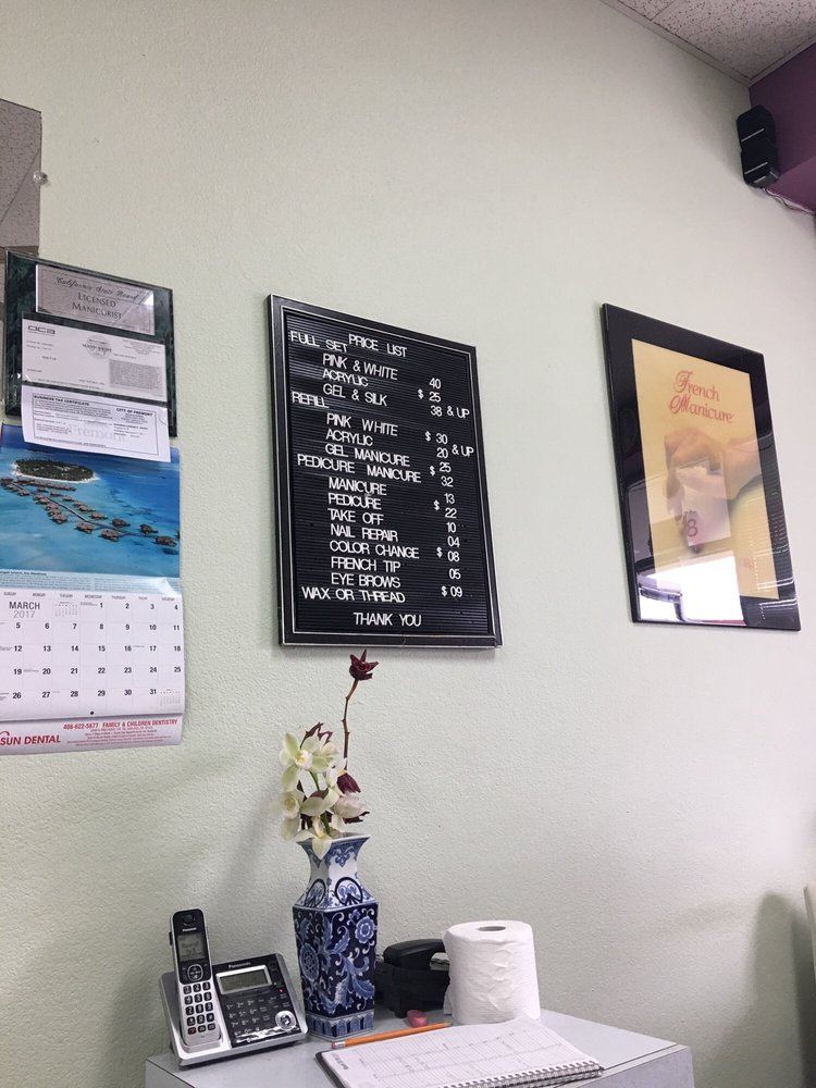 Inside Nails Perfection: a letter-board menu, California manicurist license, and a blue-and-white vase on the desk.