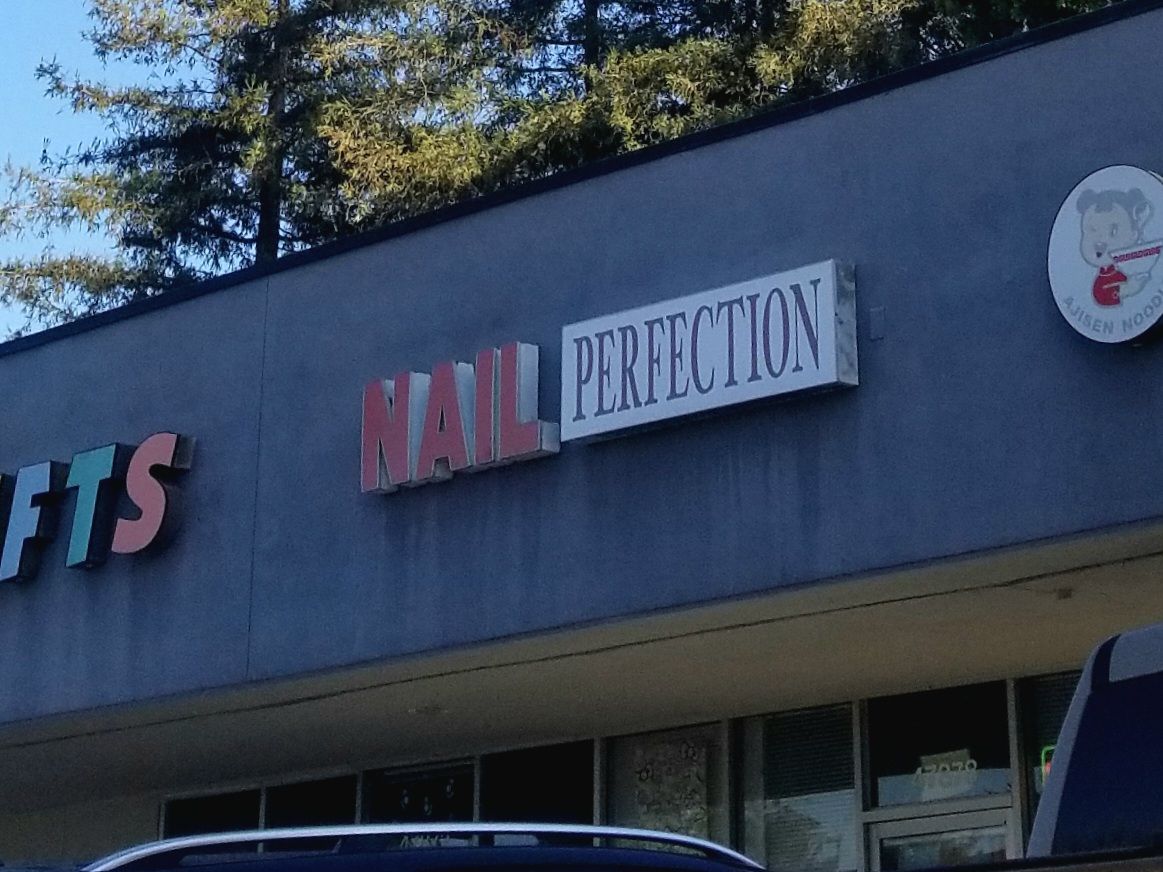 Close-up of the NAIL PERFECTION sign on the Warm Springs plaza.