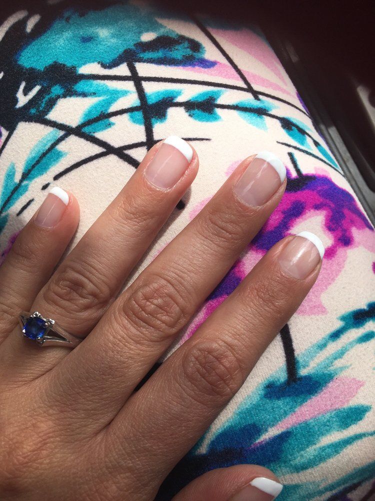 Short French-tip nails in sunlight.